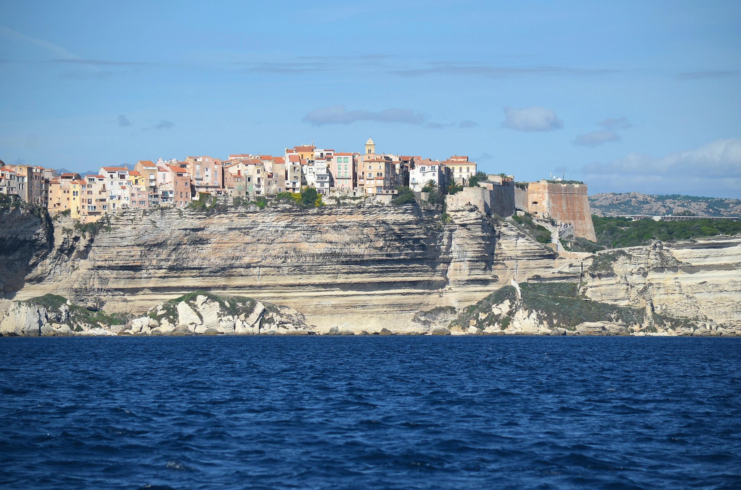 Photo emblématique de Bonifacio prise depuis la mer au pied des falaises